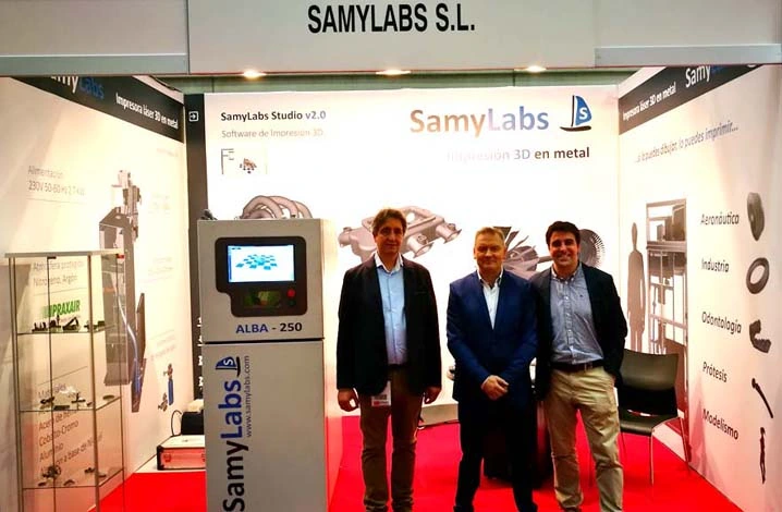Stand de SamyLabs en ADDIT3D 2017, con el prototipo ALBA 250 y tres personas del equipo delante del expositor