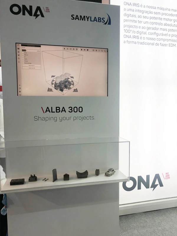 Panel del stand con la ALBA 300 y una muestra de piezas metálicas impresas