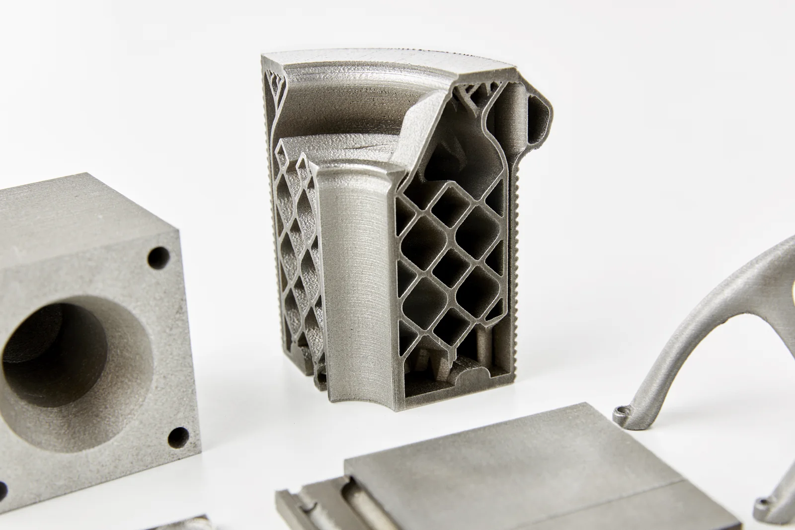 Detalle de piezas impresas en metal con estructura reticular interna y superficie de fabricación