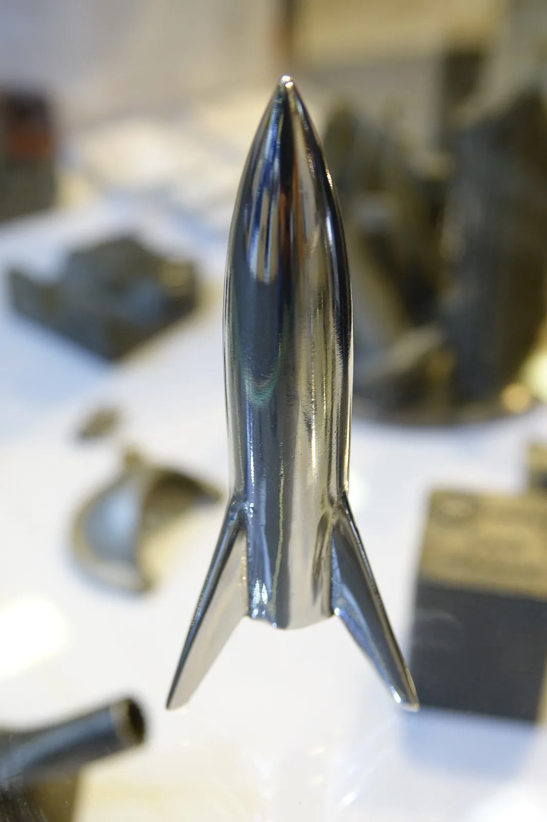 Figura de cohete impresa en metal y pulida a espejo